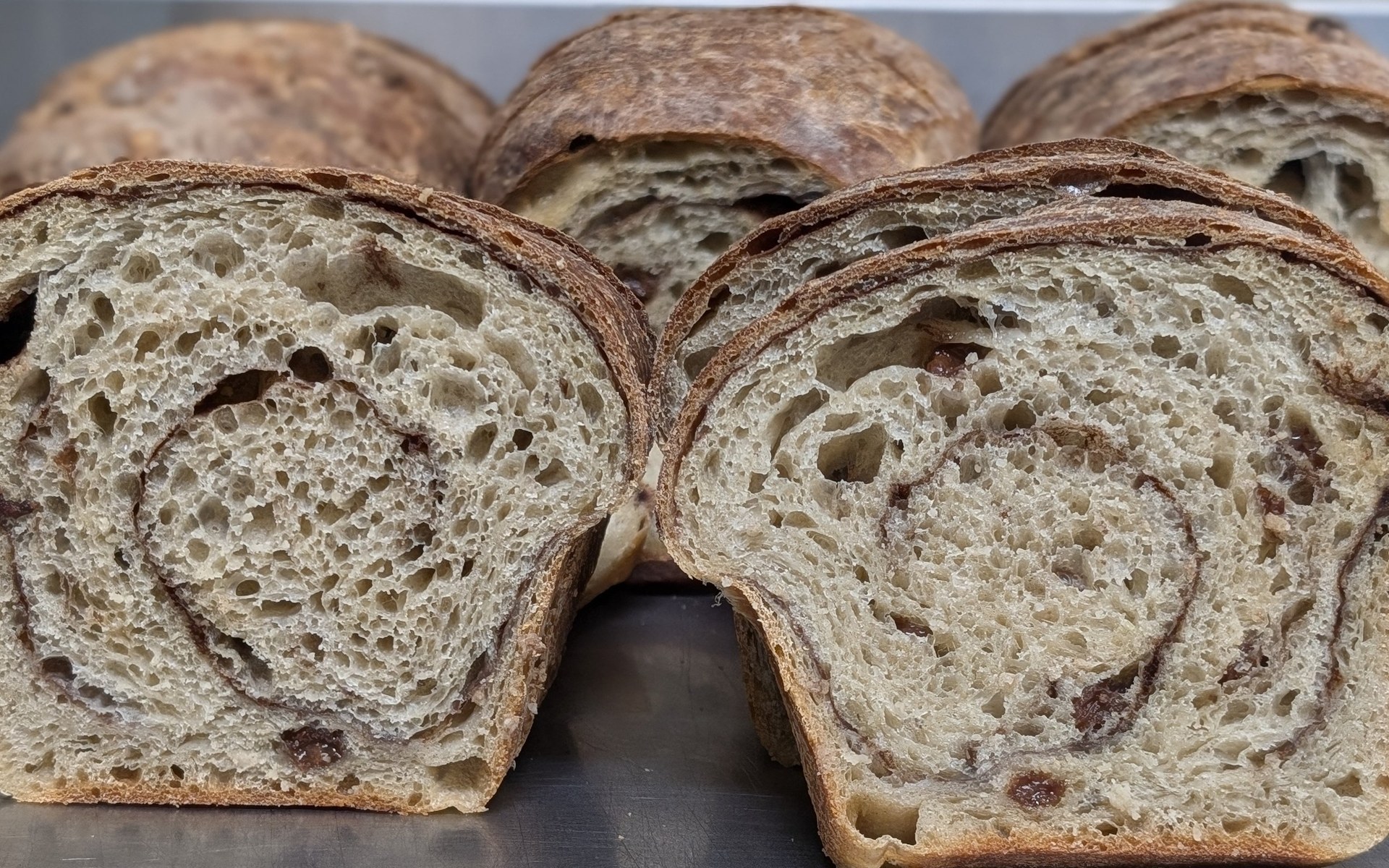 Sliced specialty sourdough loaves showing their swirled crumb.